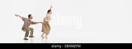 Coppia in stile vintage che danzano energicamente con abiti a tema retrò su sfondo bianco. Banner Foto Stock