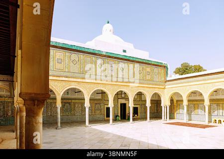 Colonnato decorato con piastrelle colorate e cortile interno della Moschea Zaouia Sidi Abou Zamaa (Moschea Barbiera, Zawiya di Sidi Sahib, Zaouia de Sidi Sahab) nel centro della città di Kairouan, Tunisia Foto Stock