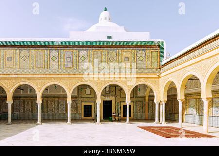 Colonnato decorato con piastrelle colorate e cortile interno della Moschea Zaouia Sidi Abou Zamaa (Moschea Barbiera, Zawiya di Sidi Sahib, Zaouia de Sidi Sahab) nel centro della città di Kairouan, Tunisia Foto Stock