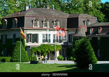 Chäteau de Penthes con la bandiera nazionale svizzera e la bandiera del Cantone di Ginevra nel Parco di Penthes, Pregny-Chambesy, Ginevra, Svizzera Foto Stock