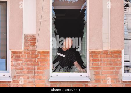 Un uomo pulisce il vetro rotto dalle finestre frantumate in un salone di parrucchiere a seguito di un attacco di droni russi, Poltava, Ucraina, il 3 luglio 2025 (foto di Viacheslav Madiievskyi/Ukrinform) Foto Stock