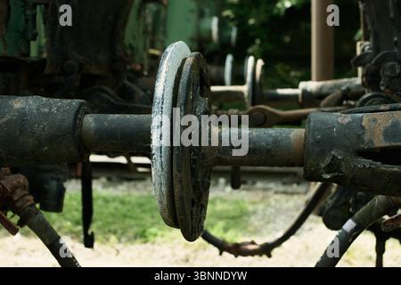 Accoppiatore per treni con piastra tampone meccanica centrale, componenti in metallo arrugginito, bielle usurate e corrosione visibile, catturati in un rai esterno Foto Stock