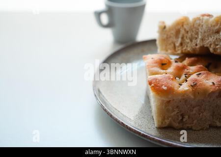 Focaccia italiana fatta in casa e caffè espresso per colazione su sfondo bianco, spazio copie Foto Stock