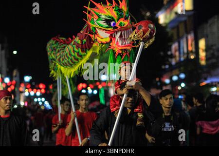 Un ragazzo si unisce al carnevale del Festival del Drago di Jogja nella serie della XI settimana culturale di Yogyakarta che si svolge lungo via Malioboro. Foto Stock