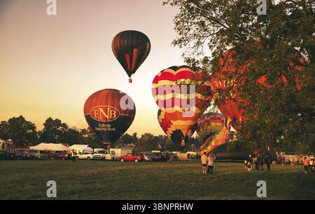 Vista di molti mongolfiere pronti a decollo in un festival delle mongolfiere di prima mattina Foto Stock