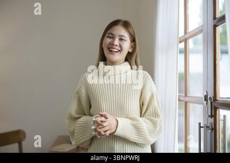 Felice donna asiatica sorridente e fiduciosa. rilassatevi a casa Foto Stock