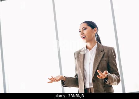 Un agente immobiliare di fiducia parla delle opzioni di proprietà in un elegante ambiente di ufficio Foto Stock