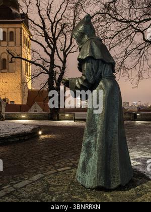 Statua in bronzo del monaco medievale di notte, Chiesa di San Nicola, città vecchia di Tallinn, Estonia. Foto Stock