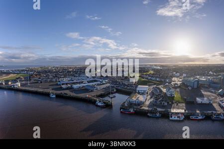 Veduta aerea del porto dove il fiume Coquet incontra il Mare del Nord, la città annidata nell'entroterra sotto un cielo soleggiato, Morpeth, Inghilterra, Regno Unito. Foto Stock