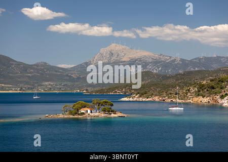Chiesa greco-ortodossa su una piccola isola al largo della baia russa con acque turchesi cristalline, Poros, Golfo Saronico, isole greche, Grecia, Europa Foto Stock