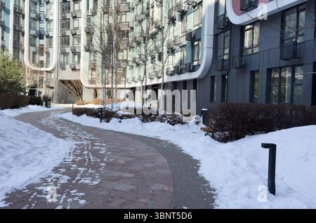 Ucraina, Kiev - 18 febbraio 2025: Terrapieno invernale nel parco di Kiev. River Mall Park. Vicino ai nuovi edifici a più piani. Foto Stock
