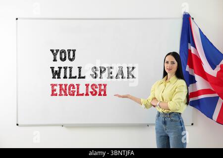 Insegnante che indica il testo parlerà inglese sulla lavagna bianca. Corso di lingua Foto Stock