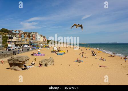 Boscombe, Bournemouth, Dorset, Inghilterra, Regno Unito, venerdì 4 luglio 2025, Meteo: persone sulla spiaggia con caldo sole estivo pomeridiano sulla costa meridionale prima di cambiare il clima piovoso durante il fine settimana. Foto Stock