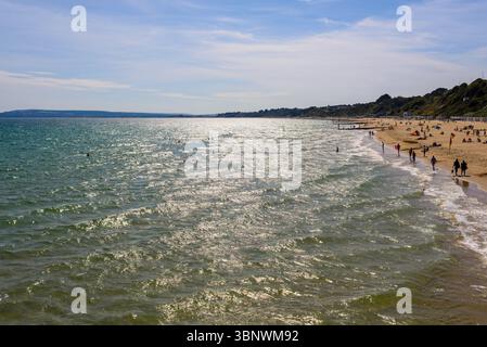 Bournemouth, Dorset, Inghilterra, Regno Unito, venerdì 4 luglio 2025, Meteo: Persone sulla spiaggia con caldo sole estivo pomeridiano sulla costa meridionale prima di passare al tempo piovoso durante il fine settimana. Foto Stock
