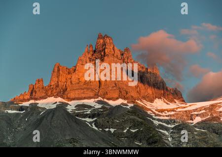 L'Alpenglow bagna le torri rocciose frastagliate del Großer Spannort (3.198 m) in una calda luce serale sopra l'alpe di Hobiel. Visto dall'alpe, il picco si erge sopra il ghiacciaio di Spannort all'estremità della valle di Engelberg. Alpe di Hobiel, Attinghausen, Canton Uri, Svizzera. Foto Stock