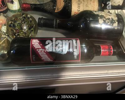 Bottiglia etichettata con il ritratto di Adolf Hitler, presentata su uno sfondo neutro, catturando controversi cimeli storici del vino. Foto Stock