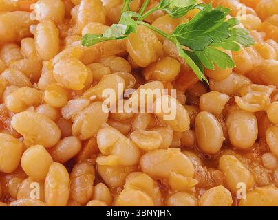 Natura morta del cibo, fagioli bolliti con pomodoro e spezie da vicino Foto Stock