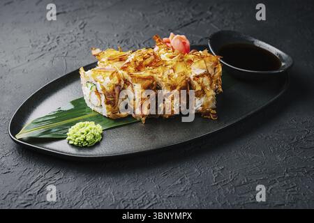 Natura morta del cibo, panino di sushi bonito su un piatto scuro Foto Stock