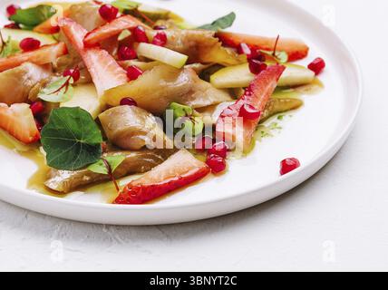 Natura morta, pesce con fragole, pere e melograni in salsa Foto Stock