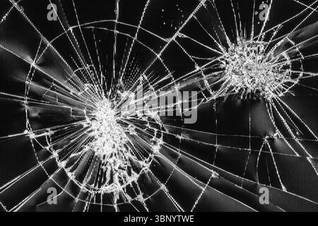 Tracce di urti e crepe su uno schermo LCD rotto, monitor di computer o TV, foto in bianco e nero, foto in bianco e nero Foto Stock