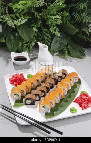 Food STILL-Life, un assortimento di sushi roll elegantemente disposti su un piatto bianco. Il piatto presenta panini colorati insieme allo zenzero sottaceto ed era Foto Stock
