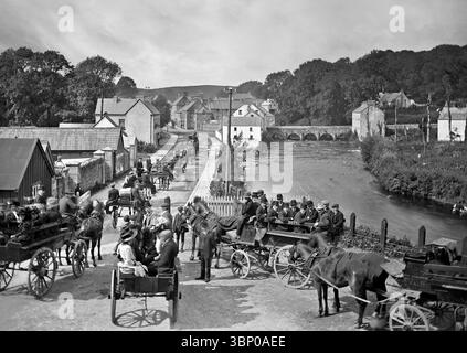 Una fotografia dei primi anni del XX secolo di pellegrini lungo il fiume Termon a Pettigo, Contea di Donegal, Irlanda. Sulla rotta per Inis Cealtra, nota anche come Inishcaltra o Holy Island, un'isola al largo della costa occidentale di Lough Derg in Irlanda, un tempo un insediamento monastico, ma ora disabitata. Foto Stock