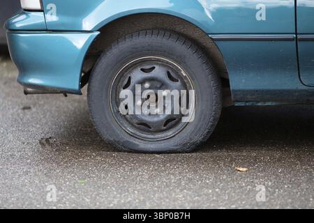 Pneumatico sgonfio, ruota danneggiata sull'antenna smarrita della vettura Foto Stock