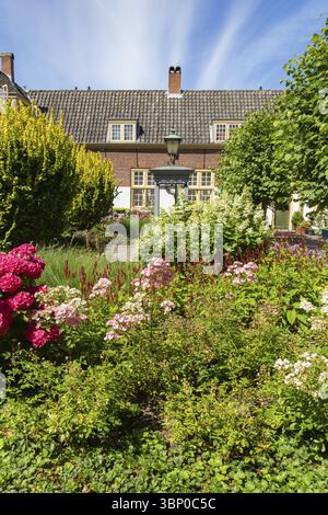 Cortile con giardino colorato e piccole case nel centro della città di Leida, nei Paesi Bassi Foto Stock
