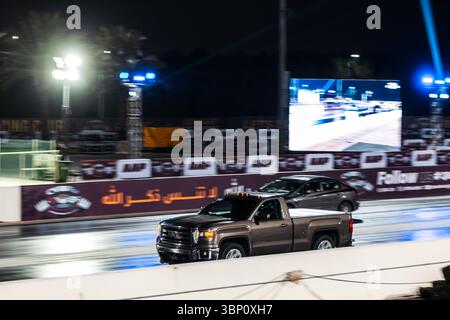 Motion Blur Night Time Drag racing, evento che mostra auto in competizione sul tracciato con spettatori nelle vicinanze Foto Stock