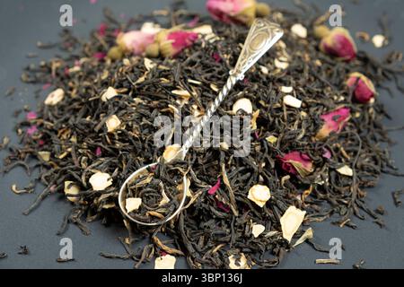 Composizione del tè nero con pezzi di ginseng e rose del tè Foto Stock