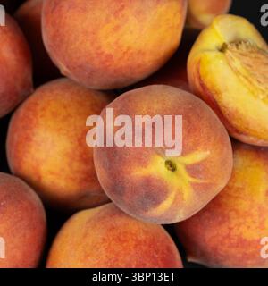 Un mucchio di pesche intere mature in primo piano. Foto Stock