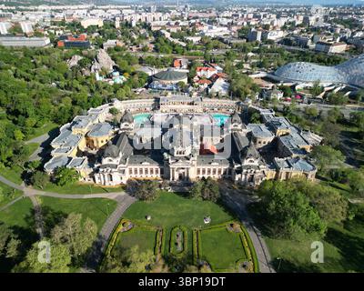 Foto aerea simmetrica ad angolo superiore del bagno termale di Széchenyi, incentrata sulla cornice, con giardino frontale, parti del Circo della capitale e dello zoo di Budapest Foto Stock