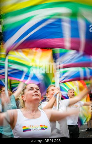 Londra, Regno Unito. 5 luglio 2025. Un gruppo riscalda la sua routine di danza delle bandiere. Partecipanti e spettatori alla Pride in London 2025 Parade. Quest'anno, la sfilata comprende circa 500 gruppi con oltre 33.000 partecipanti, oltre a palchi sonori lungo il percorso, a Trafalgar Square e nei dintorni di Soho. Pride celebra la diversità, la tolleranza e la comunità LGBT. Tra le celebrità della sfilata figurano Naomi Campbell, Edward Enniful, Paloma Faith, Vanessa Wiliams con i membri del cast di "The Devil Wears Prada", Nicola Adams e il sindaco di Londra. Credito: Imageplotter/Alamy Live News credito: Imageplotter/Alamy Live New Foto Stock