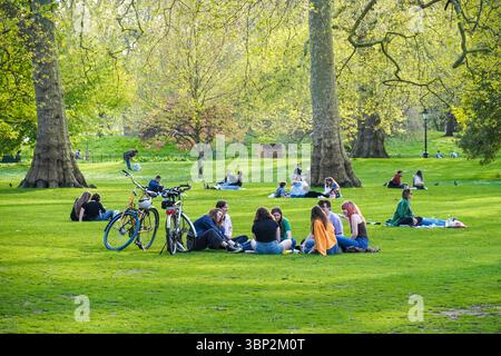 I giovani si godono una giornata di sole a St James's Park, Londra Inghilterra Regno Unito Foto Stock