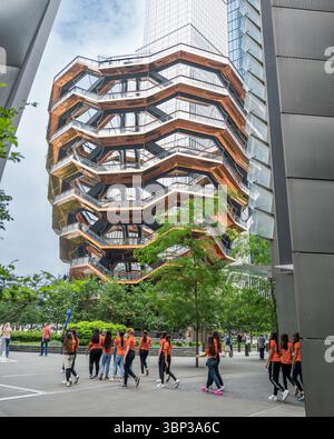 Gruppo turistico sotto la nave a New York City Hudson Yards - iconica attrazione turistica nel centro di Manhattan - turisti in camicie abbinate Foto Stock