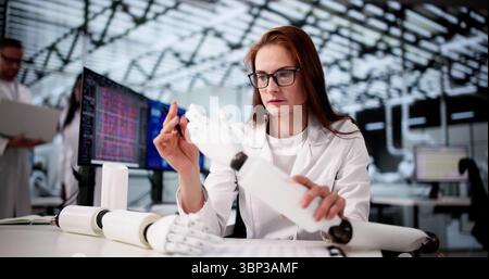 Giovane donna in ufficio che progetta braccio protesico robotico per pazienti. Foto Stock