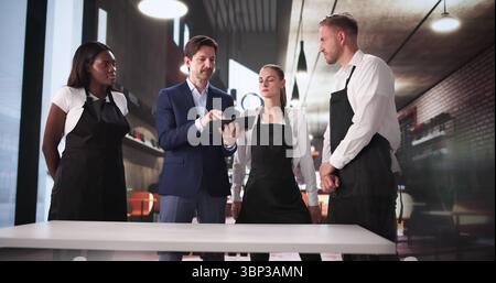 Giovane manager afroamericano che si collega con il team del negozio al Cafe. Foto Stock