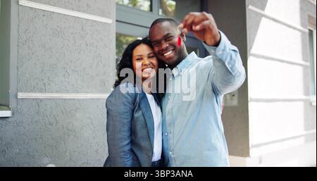 Felice coppia di sposi che tiene insieme le chiavi alla First Home, eccitata. Foto Stock