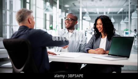 Giovane coppia che guarda con piacere il Real Estate con diversi Realtor Advisor. Foto Stock