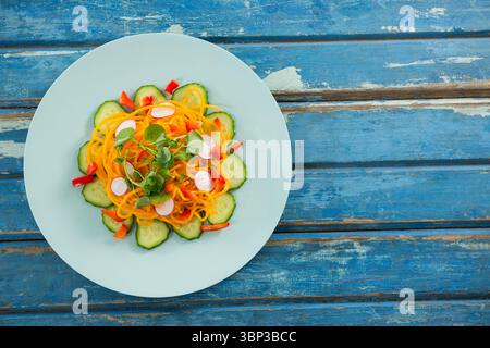 Insalata fresca nella piastra circolare sul tavolo di legno Foto Stock