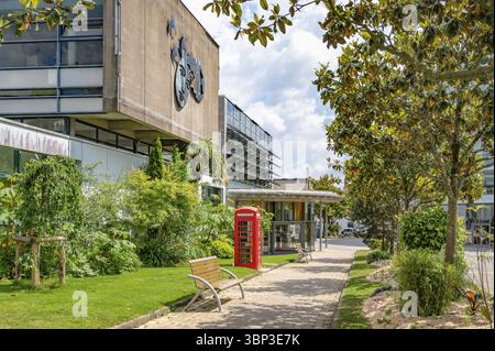 Riqualificazione urbana ecologica con vegetazione sul sentiero pedonale con panca e cabina telefonica rossa britannica di fronte alla mediatea Benjamin Rabi Foto Stock