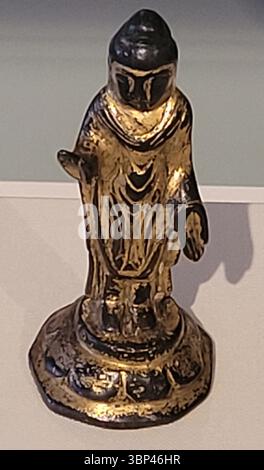 Una fotografia ravvicinata di un'antica statua coreana di Buddha in bronzo dorato del periodo unificato Siulla (668?935 d.C.), con resti di doratura dorata e una forma semplice e allungata. L'arte buddista fiorì in Corea durante e dopo il periodo dei tre Regni (circa 57 a.C. 668 CE), a seguito dell'introduzione del buddismo dalla Cina. Le statue in bronzo dorato erano molto apprezzate, spesso commissionate da reali e aristocratici, e rappresentano importanti espressioni religiose e artistiche dell'epoca. Riflettono sia la sensibilità artistica coreana indigena che le influenze dell'icona buddista cinese Foto Stock