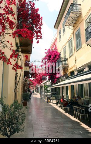 Una fotografia di una strada coperta di bouganville a Nauplio o Nauplio, una città costiera situata nel Peloponneso in Grecia. È la capitale dell'unità regionale dell'Argolide e un'importante destinazione turistica. Fondata nell'antichità, la città divenne un importante porto marittimo nel Medioevo durante la Frankokratia come parte della signoria di Argo e Nauplia, inizialmente detenuta dai de la Roche dopo la quarta crociata prima di passare sotto la Repubblica di Venezia e, infine, l'Impero ottomano. La città fu la seconda capitale della prima Repubblica ellenica e del Regno di Grecia, dal 1827 Foto Stock