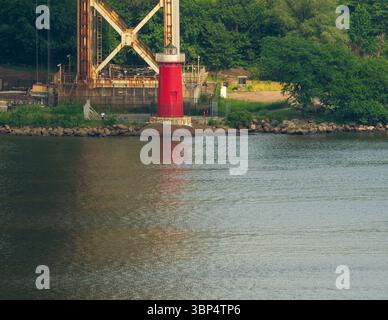 New York, NY - US - 2 luglio 2025 l'iconico Little Red Lighthouse sorge sotto il George Washington Bridge, annidato lungo la roccia del fiume Hudson Foto Stock