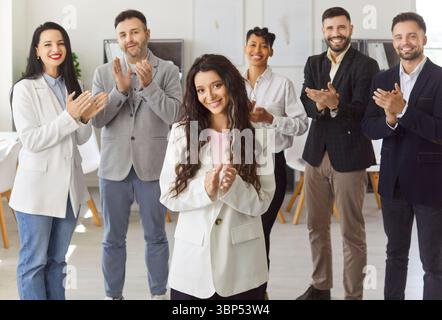 Felice gruppo eterogeneo di colleghi che applaudono, celebrano i risultati, la leader donna applaude Foto Stock