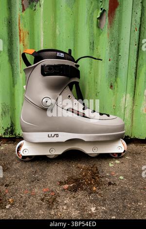 Lublino, Polonia 08 maggio 2025 Grey Carols Bernal Kizer pattinaggio in linea fuori dalla porta di un garage verde - pacchetto sportivo estremo urbano Foto Stock