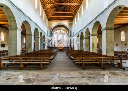 Vista dell'interno di Santa Maria e della cattedrale di San Marco sull'isola di Reichenau, Baden-Württemberg, Germania. La foto mostra l'area dell'altare con una griglia ornata in ferro battuto, una statua della Vergine Maria, storici dipinti murali e una luminosa vetrata colorata o reliquiario, che creano un'atmosfera spirituale in questo sito patrimonio dell'umanità dell'UNESCO. Münsterplatz, Reichenau, Baden-Württemberg, Germania Foto Stock