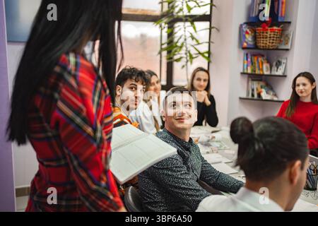 Insegnante donna che spiega il soggetto ai suoi studenti adolescenti alla scuola di lingue Foto Stock