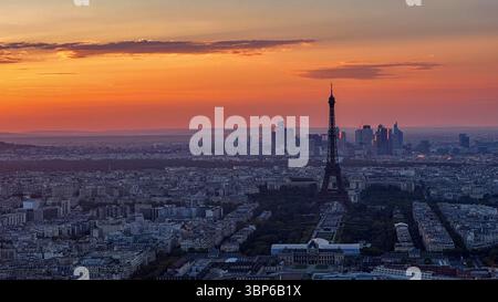 Torre Eiffel al tramonto a Parigi, Francia, con caldo cielo arancione e luce soffusa della sera Foto Stock