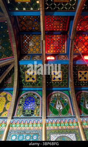 Un soffitto vivace e intricato caratterizzato da piastrelle colorate e motivi geometrici. Il design presenta un mix di motivi tradizionali con un tocco moderno, Foto Stock